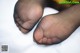 A close up of a person's feet in black stockings.