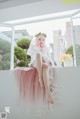 A woman in a wedding dress sitting on a window sill.