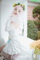 A woman in a wedding dress sitting on a window sill.