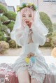 A woman in a wedding dress sitting on a bed.