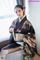 A woman in a kimono sitting on a couch.