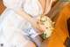 A woman in a wedding dress holding a bouquet of flowers.