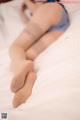 A woman laying on a bed with her legs crossed.