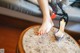 A woman's feet on a table with a pair of shoes on it.