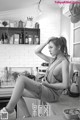 A woman sitting on top of a kitchen counter.