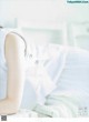 A woman laying on top of a bed next to a pillow.