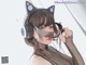 A woman wearing a black cat ears headband and headphones.