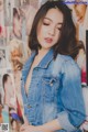 a woman in a denim jacket posing for a picture