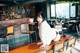 A woman sitting on top of a wooden table in a restaurant.