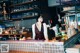 A woman standing behind a bar in a restaurant.