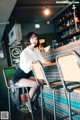 A woman sitting at a bar in a restaurant.