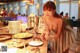 A woman sitting at a table with plates of food.