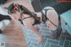 A woman in lingerie posing on a tiled floor.