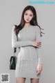 a woman in a gray sweater dress posing for a picture