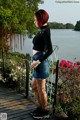 A woman standing on a wooden walkway next to a body of water.