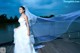 A woman in a wedding dress standing on a dock.