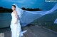 A woman in a wedding dress standing on a dock.