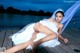 A woman in a wedding dress laying on a dock.