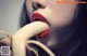 A woman with red lipstick eating a banana.