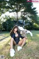 A woman sitting on a chair in the grass.