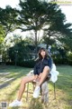 A woman sitting on a chair in a park.